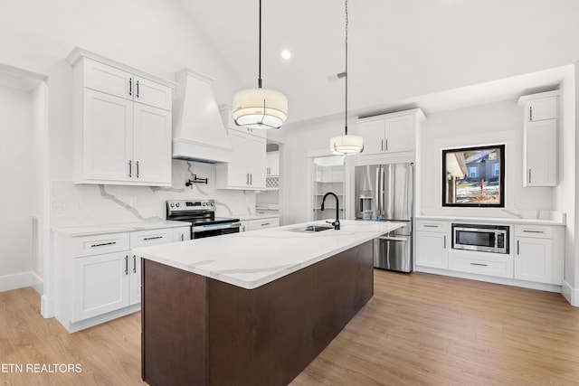 kitchen with premium range hood, decorative light fixtures, stainless steel appliances, white cabinets, and sink