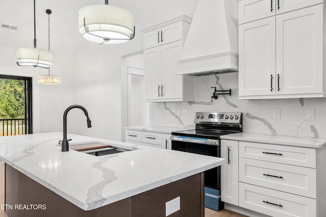 kitchen with stainless steel electric range, premium range hood, pendant lighting, sink, and white cabinetry