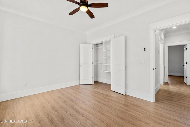 unfurnished bedroom featuring ceiling fan, light hardwood / wood-style floors, ornamental molding, and a closet