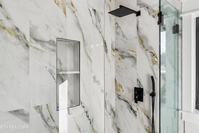 interior details featuring a tile shower