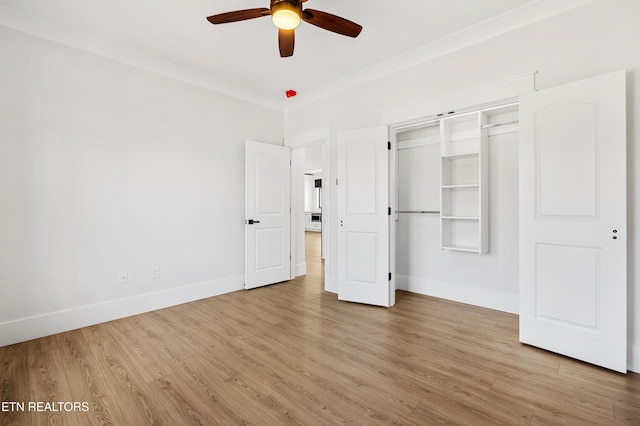 unfurnished bedroom featuring a closet, ceiling fan, crown molding, and light wood-type flooring