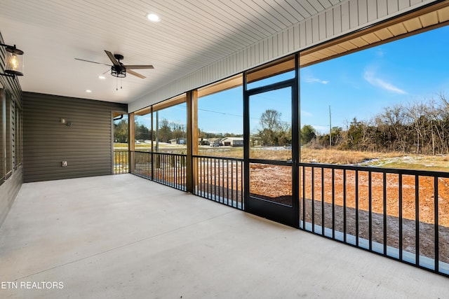 unfurnished sunroom featuring ceiling fan