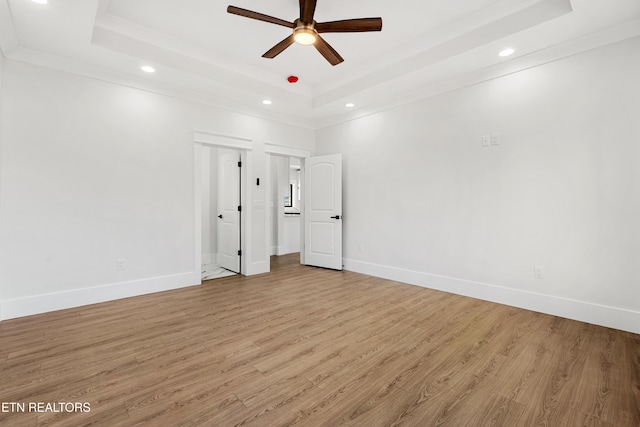 unfurnished bedroom with a raised ceiling, ceiling fan, and light hardwood / wood-style flooring