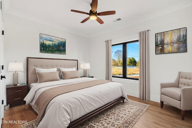 bedroom featuring ceiling fan, light hardwood / wood-style floors, and crown molding