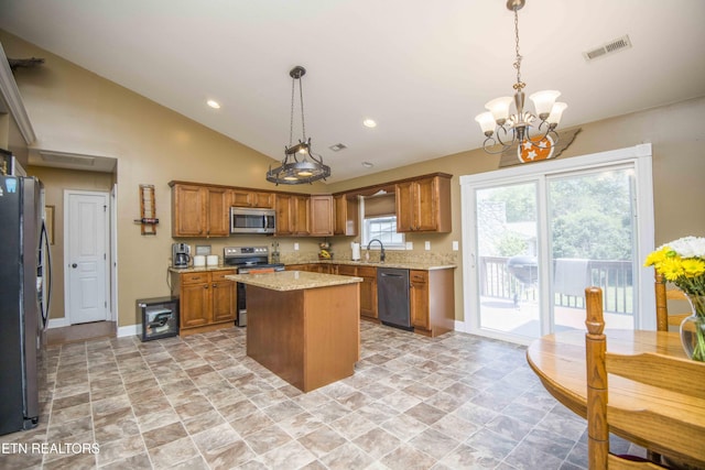 kitchen with stainless steel appliances, a chandelier, a kitchen island, and hanging light fixtures