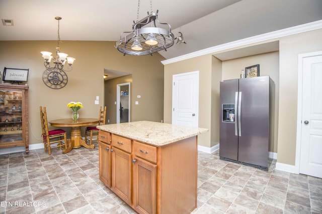 kitchen with vaulted ceiling, hanging light fixtures, stainless steel fridge, a kitchen island, and a chandelier