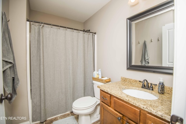 bathroom with toilet, vanity, and tile patterned floors