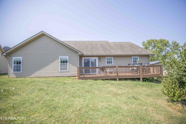 rear view of property with a yard and a wooden deck