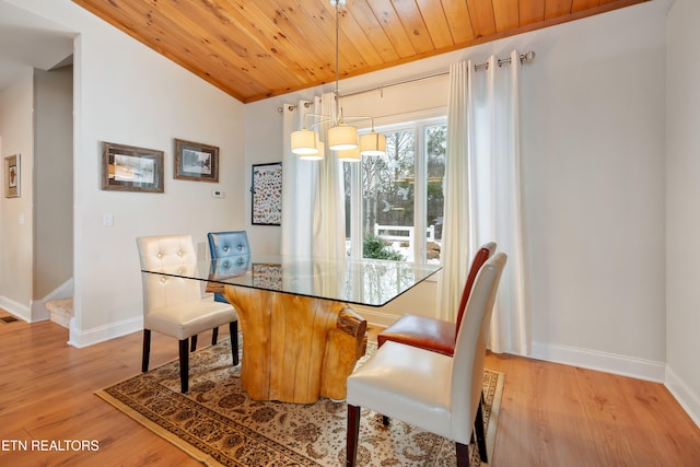 dining space with light hardwood / wood-style flooring, wooden ceiling, lofted ceiling, and a chandelier