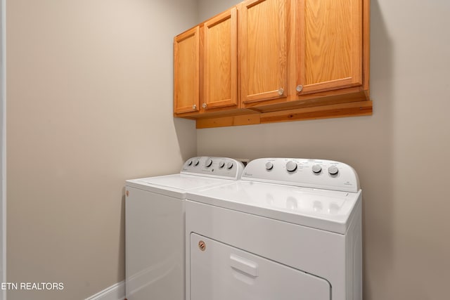 washroom featuring cabinets and washing machine and clothes dryer