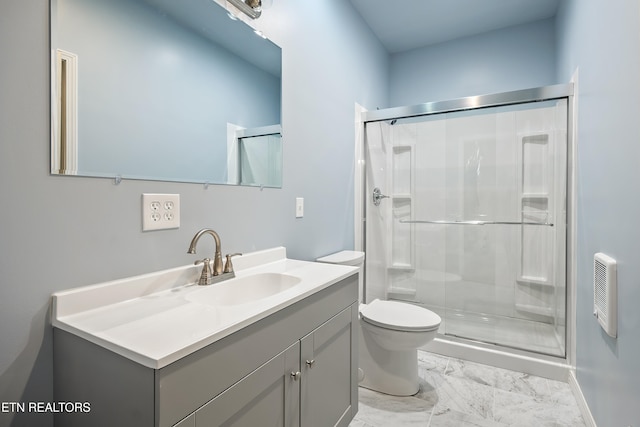 bathroom featuring toilet, a shower with door, and vanity