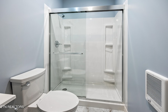 bathroom with toilet, an enclosed shower, and heating unit