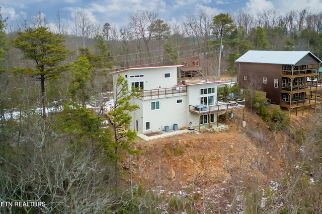 rear view of property featuring a deck and central AC unit