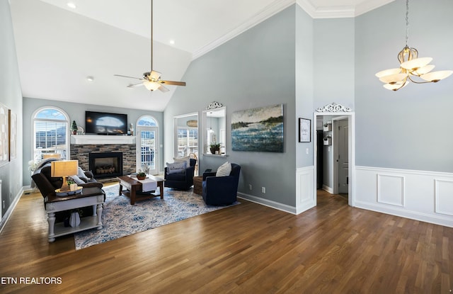 living area with a stone fireplace, a healthy amount of sunlight, and wood finished floors