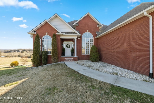 view of front of property with brick siding and a front yard