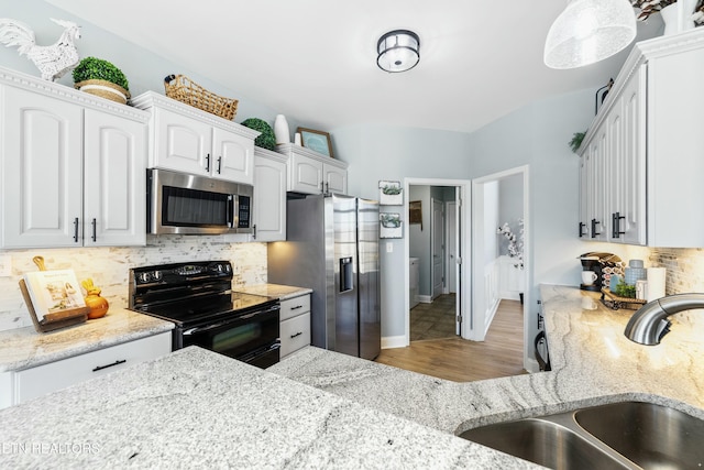 kitchen featuring a sink, stainless steel appliances, light stone countertops, and decorative backsplash