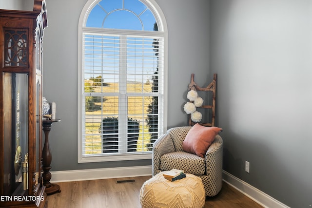 sitting room featuring visible vents, wood finished floors, and baseboards