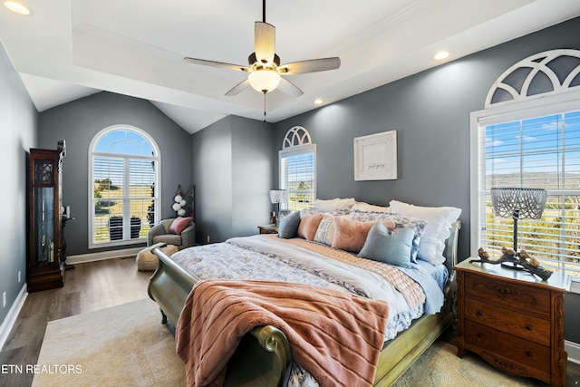 bedroom featuring baseboards, multiple windows, lofted ceiling, and light wood finished floors