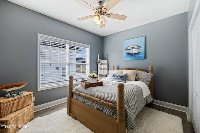 bedroom with ceiling fan, baseboards, and wood finished floors