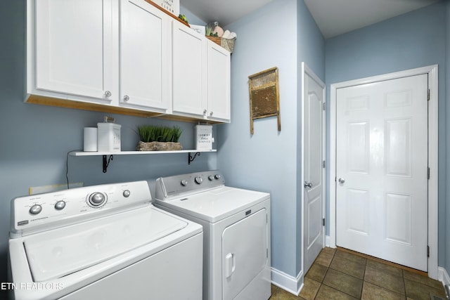 laundry room featuring separate washer and dryer, dark tile patterned floors, cabinet space, and baseboards