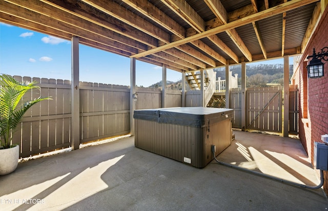 view of patio / terrace with a gate, a fenced backyard, and a hot tub