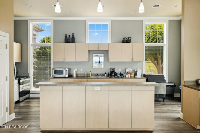 kitchen featuring white microwave, visible vents, a kitchen island, decorative light fixtures, and dark wood-style floors