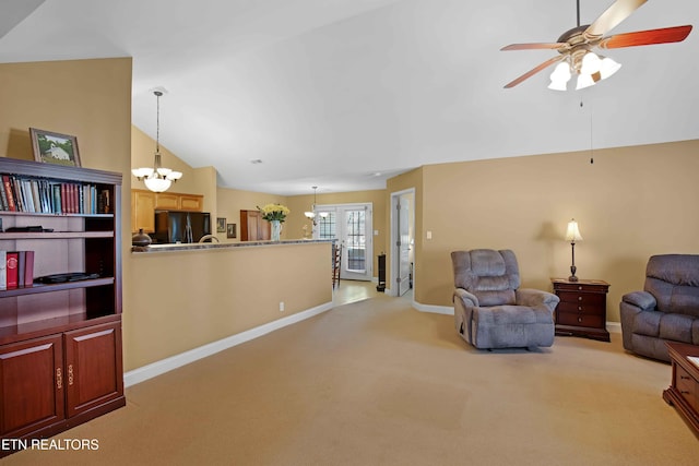 carpeted living room featuring ceiling fan with notable chandelier and lofted ceiling