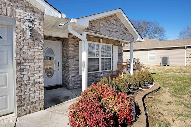 property entrance with central AC unit and a lawn