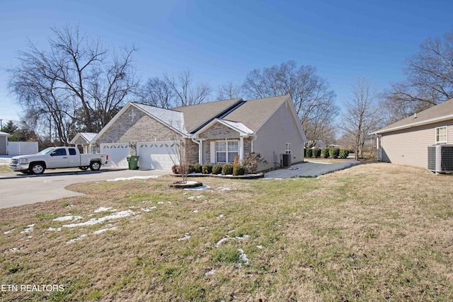 view of side of property featuring a garage, central AC, and a lawn