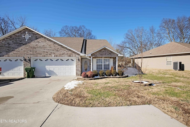 view of front of house with a front lawn, a garage, and cooling unit