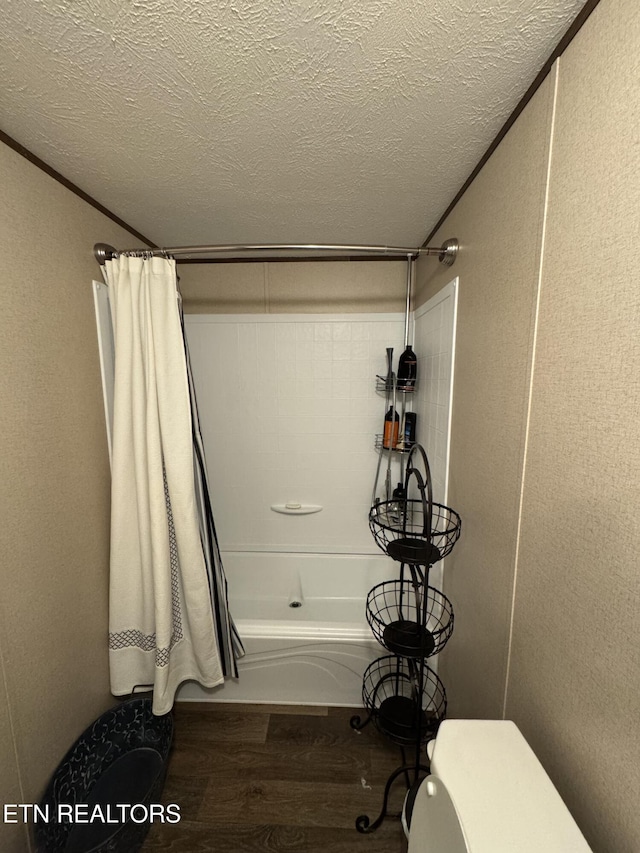 bathroom with hardwood / wood-style flooring, shower / bathtub combination with curtain, ornamental molding, and a textured ceiling