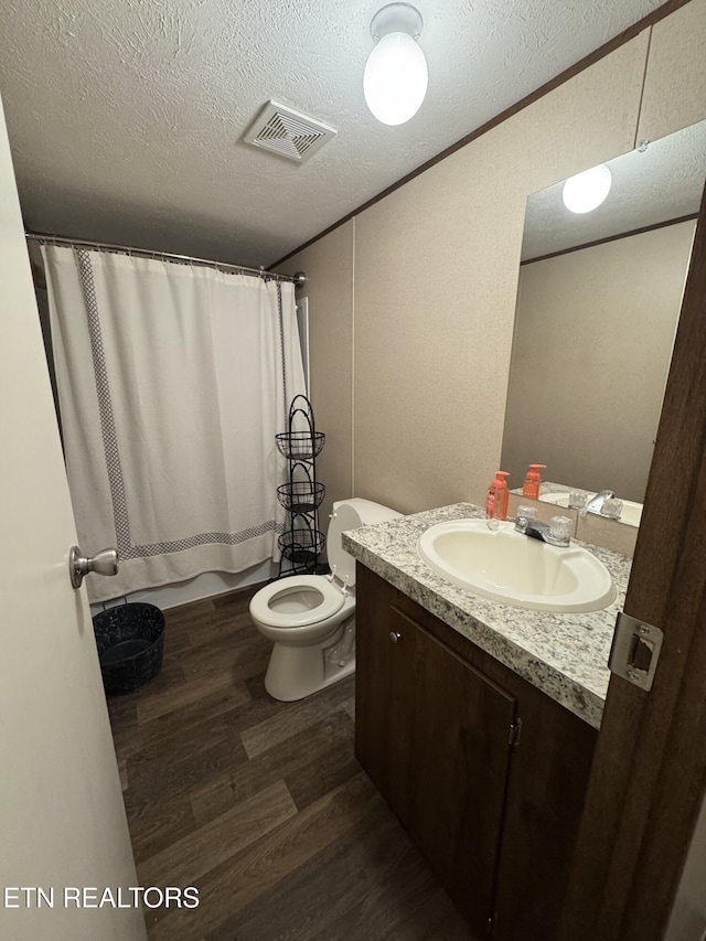 full bathroom featuring toilet, hardwood / wood-style flooring, a textured ceiling, shower / bath combination with curtain, and vanity