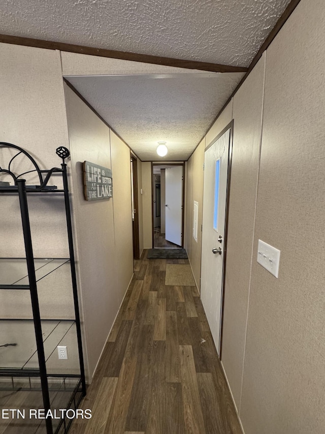 corridor featuring a textured ceiling and dark hardwood / wood-style flooring