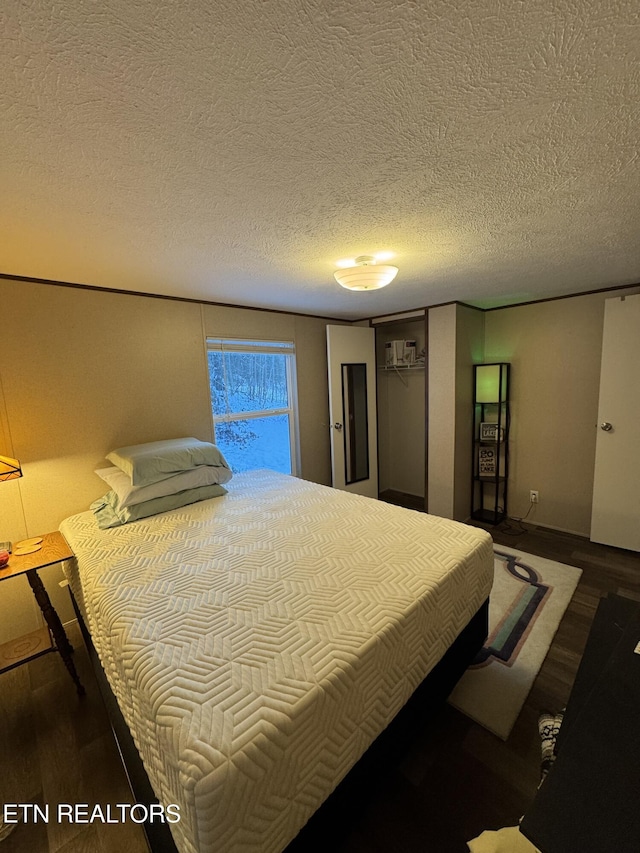 bedroom featuring a textured ceiling and hardwood / wood-style flooring