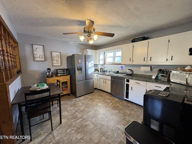 kitchen featuring sink, ceiling fan, stainless steel appliances, a textured ceiling, and white cabinets