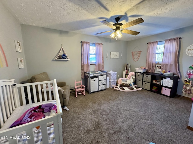 carpeted bedroom with a nursery area, a textured ceiling, and ceiling fan