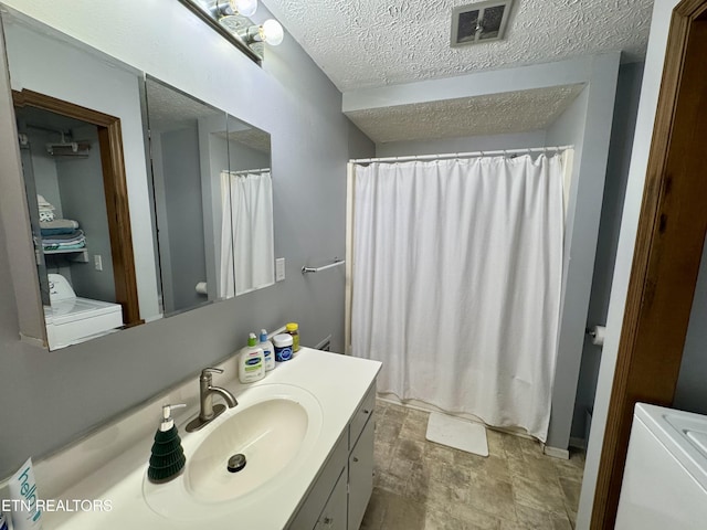 bathroom featuring vanity, washer / clothes dryer, a shower with curtain, and a textured ceiling