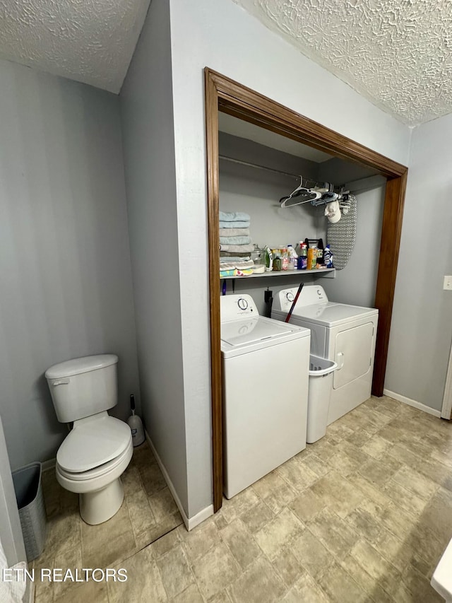 washroom with washing machine and dryer and a textured ceiling