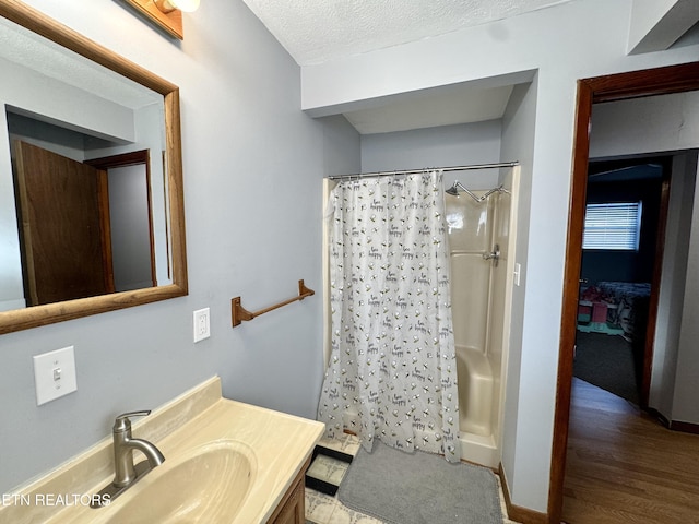 bathroom with vanity, curtained shower, and a textured ceiling