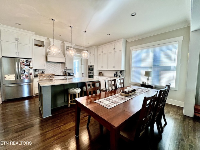 dining space featuring sink, crown molding, and dark hardwood / wood-style floors