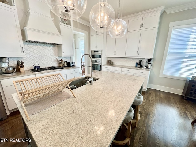 kitchen with white cabinets, a kitchen island with sink, and premium range hood