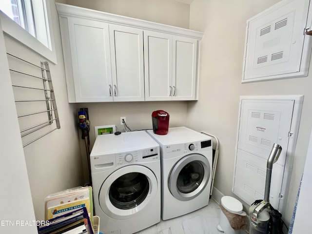 laundry room featuring washing machine and dryer and cabinets