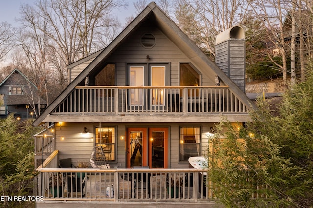 back house at dusk with a balcony