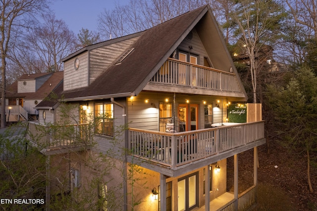 back house at dusk with a balcony