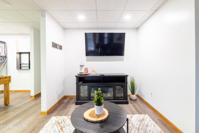 living room with hardwood / wood-style flooring and a drop ceiling