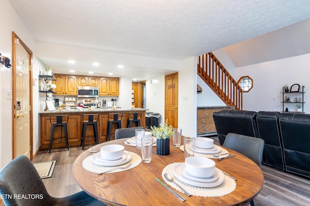 dining area with dark hardwood / wood-style flooring and a textured ceiling