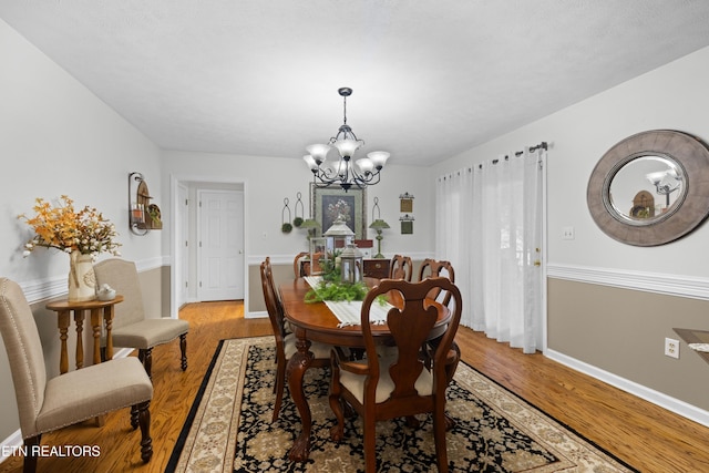 dining area featuring an inviting chandelier and hardwood / wood-style floors