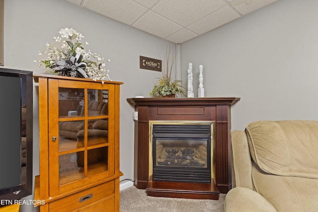 living area featuring carpet flooring and a paneled ceiling