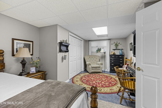 bedroom with a closet and a paneled ceiling