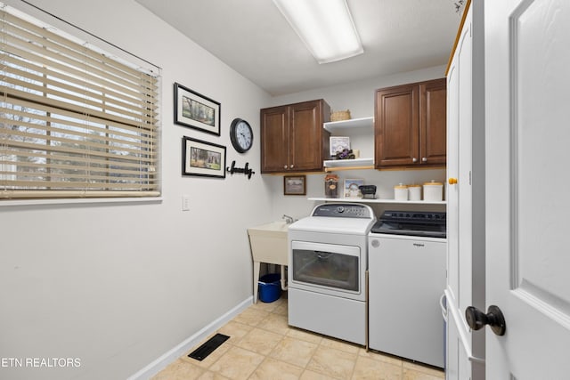 laundry area with cabinets and washing machine and clothes dryer